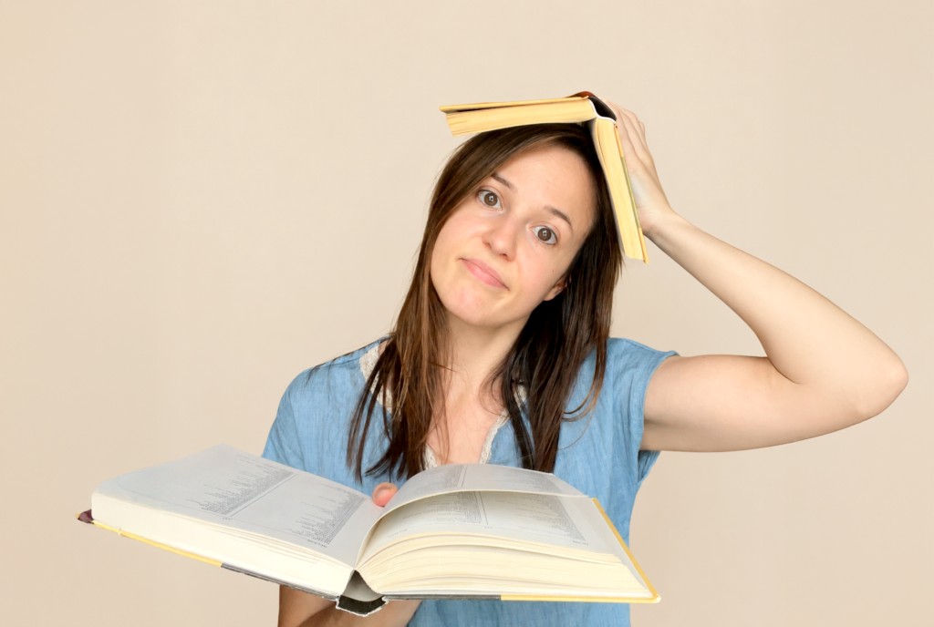 Overwhelmed student with books